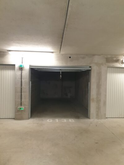 Garage de 15 m2 environ avec éclairage et prise électrique, porte basculante fermant à clés